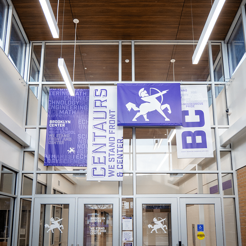 Entryway of Brooklyn Center High School with brand flags hanging from the ceiling